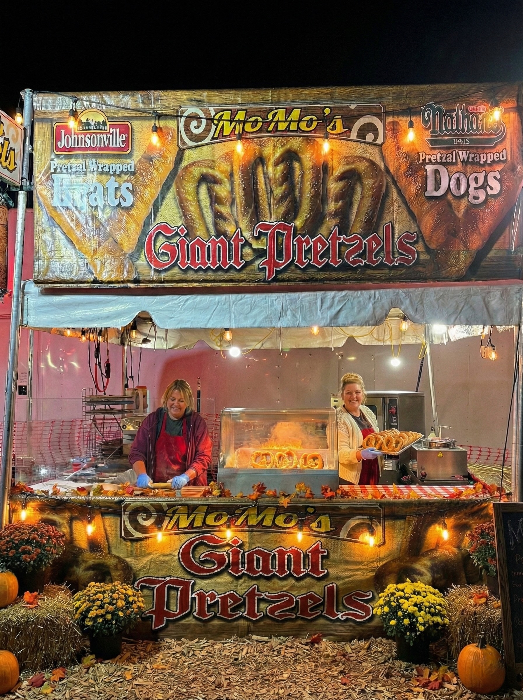 Momo smiling while holding freshly baked pretzels at the farmers market